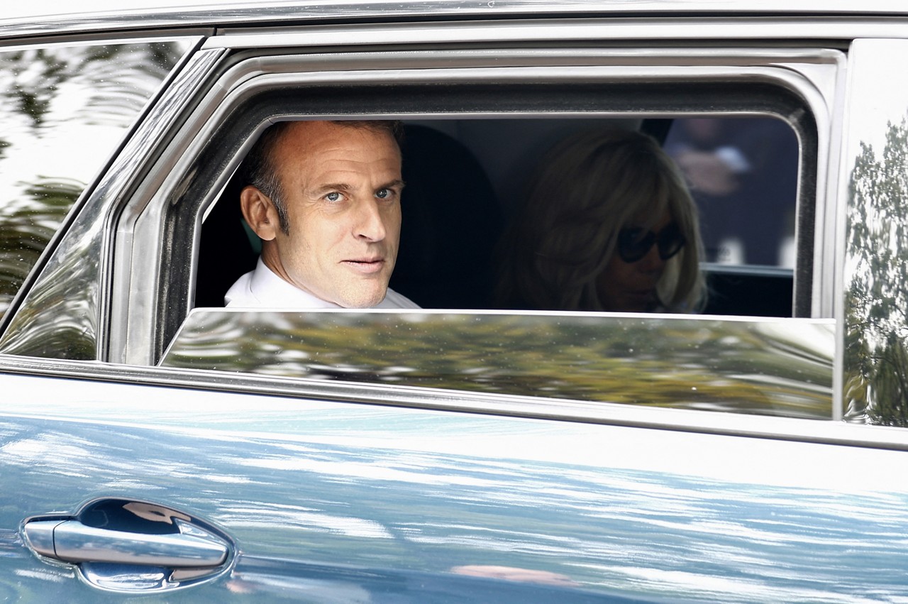 's President Emmanuel Macron (L) and his wife Brigitte Macron (R) leave by car after voting in the second round of 's legislative election at a polling station in Le Touquet, northern  on July 7, 2024.  votes in legislative elections on July 7, 2024 that will be decisive in determining its political future and could see the far right become the largest party in parliament for the first time. (Photo by MOHAMMED BADRA / POOL / AFP)
