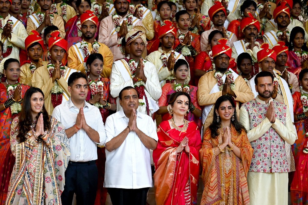 Mukesh Ambani (terceiro da esquerda para a direita ao pé da foto) é o homem mais rico da Ásia