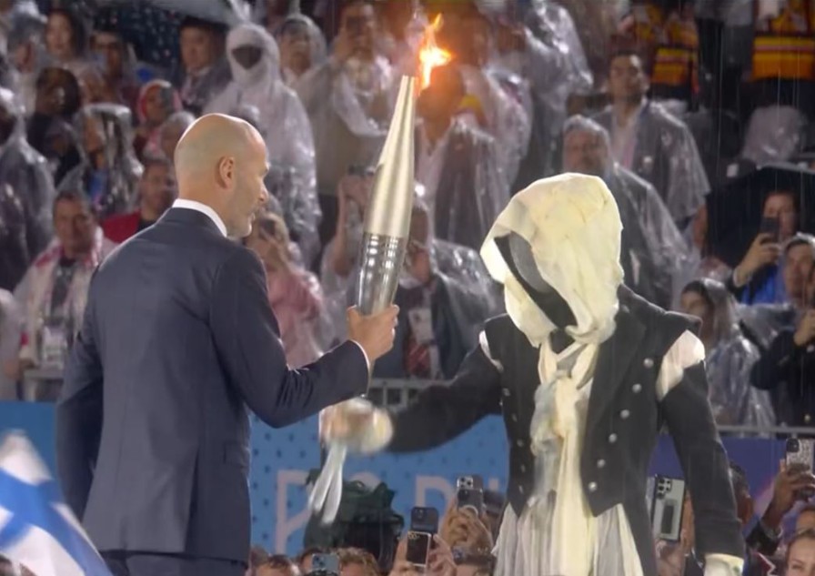 Mascarado entrega a tocha para Zinedine Zidane