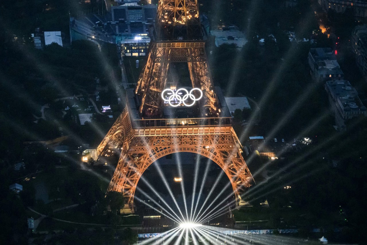Uma fotografia tirada de um helicóptero em 26 de julho de 2024 mostra uma vista aérea da Torre Eiffel e dos Anéis Olímpicos iluminados durante a cerimônia de abertura dos Jogos Olímpicos de Paris 2024 em Paris.