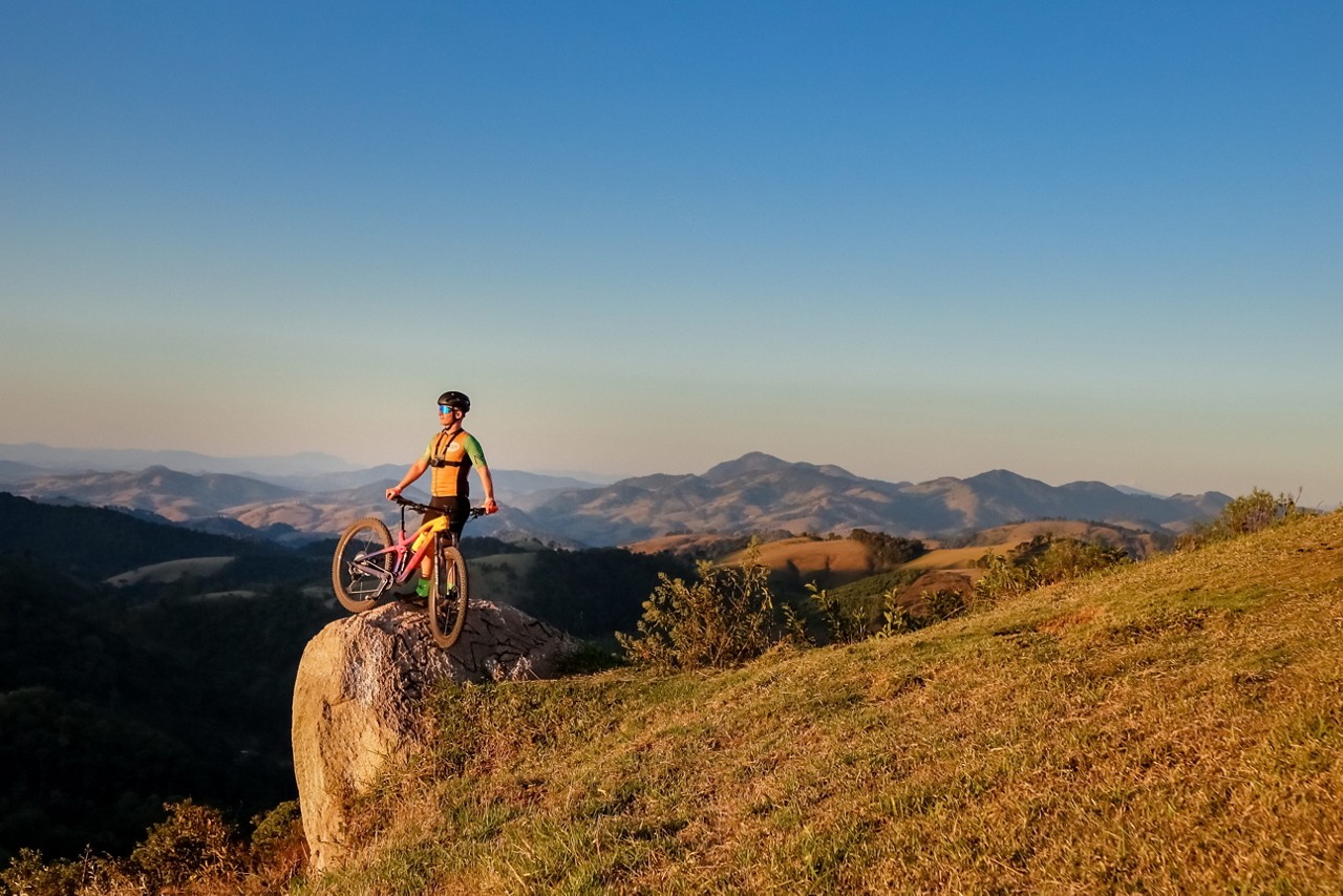 Ciclista contempla a paisagem do pico da Raposa, em Córrego do Bom Jesus, na Rota Verde