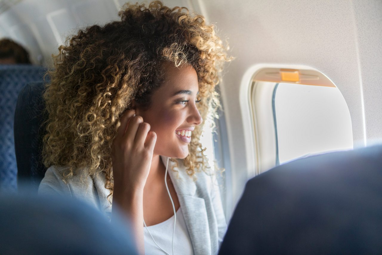 Woman looking out of a plane window