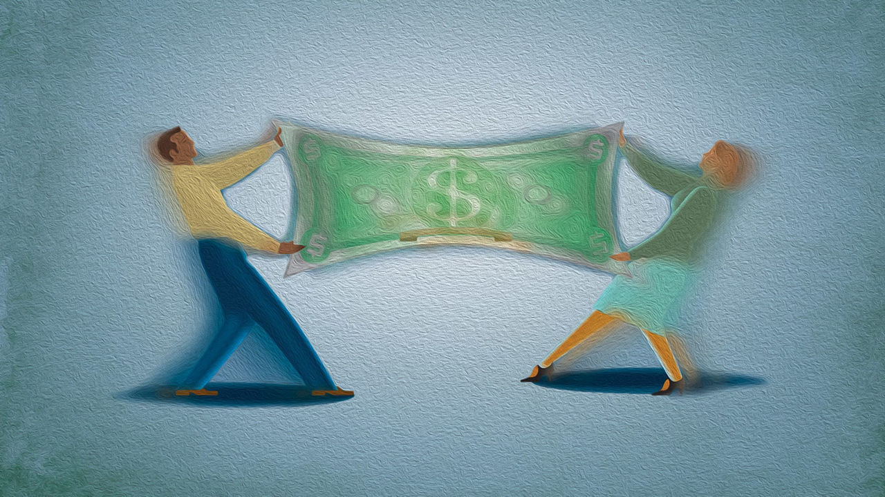 Two people holding a dollar bill in their hands.