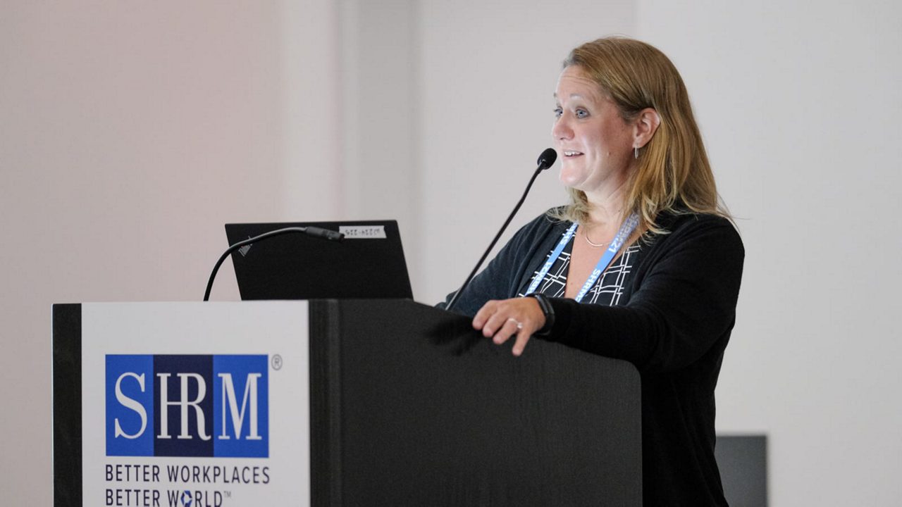 A woman giving a speech at a podium.