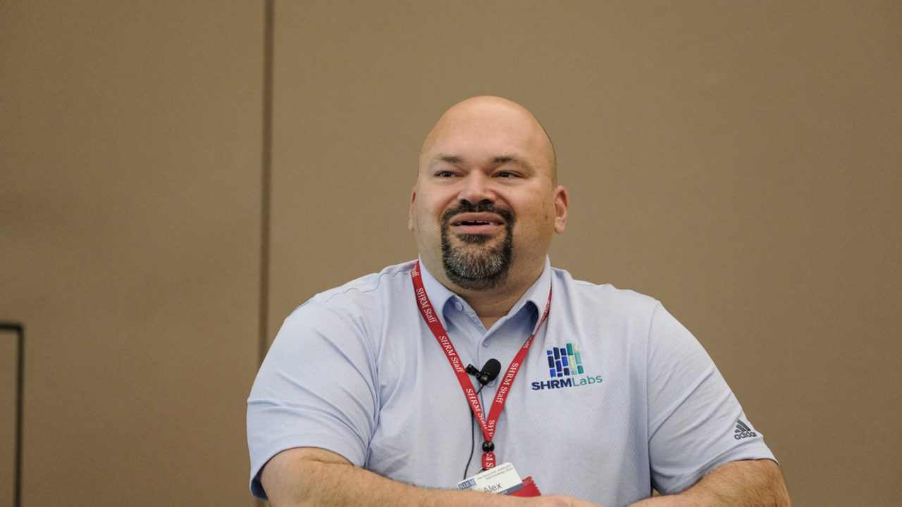 A man in a blue shirt sitting at a table.