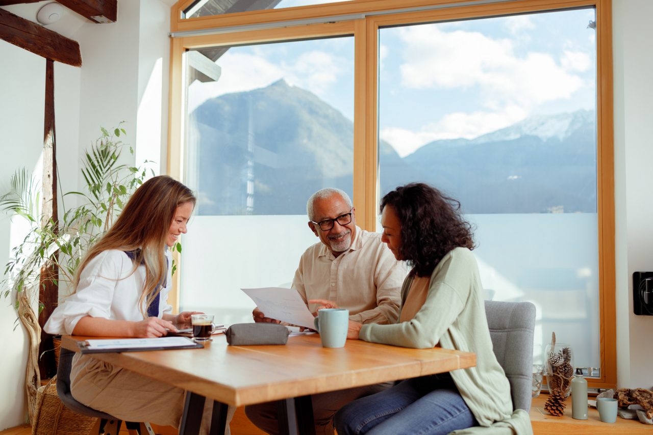 Three people gathered around paperwork