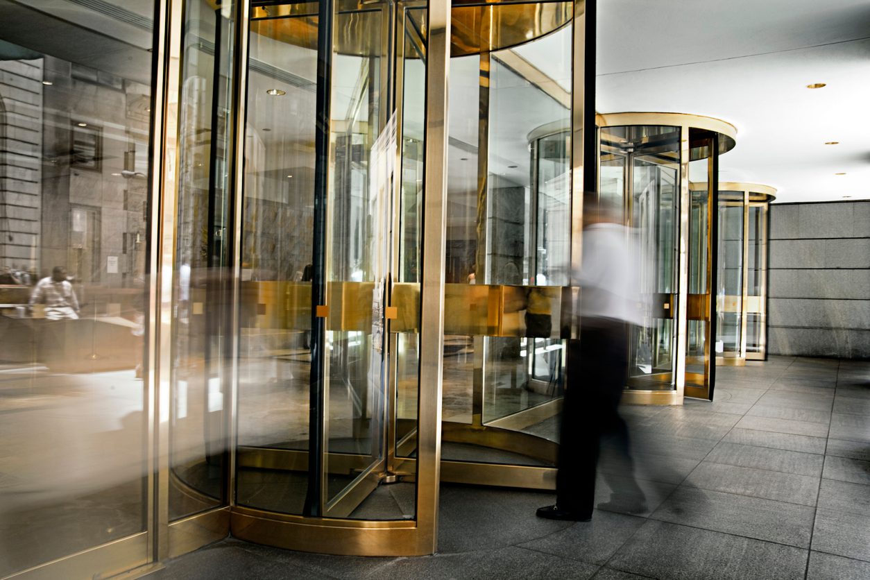 people moving in and out of a revolving door