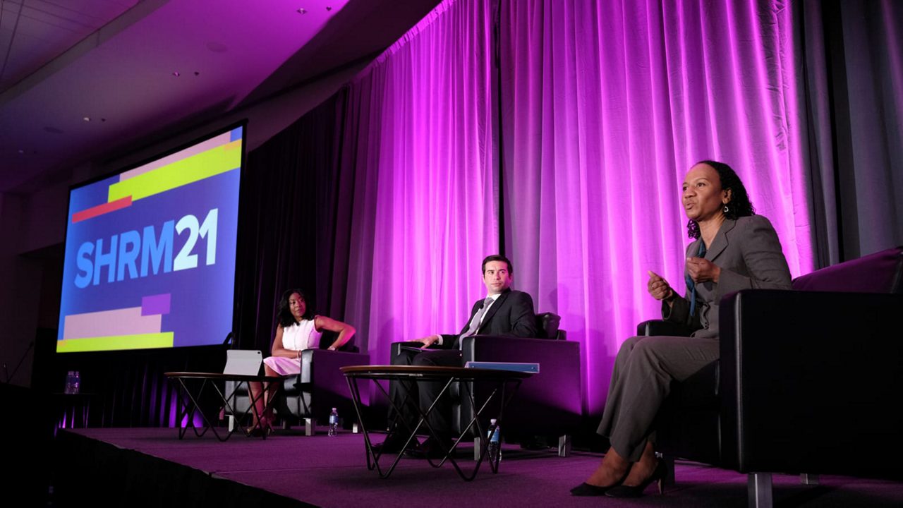 Three people on stage at the shrm 21 conference.