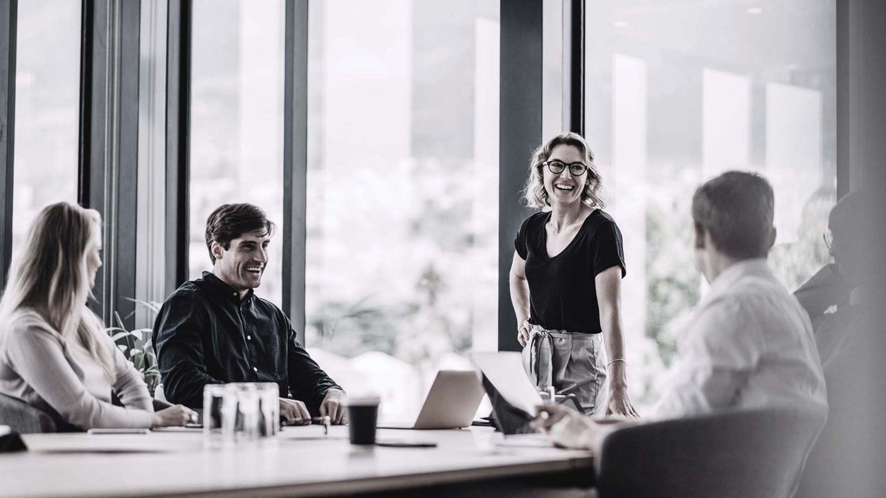 A group of people sitting around a table in a conference room.