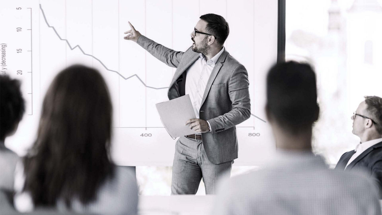A businessman giving a presentation to a group of people.