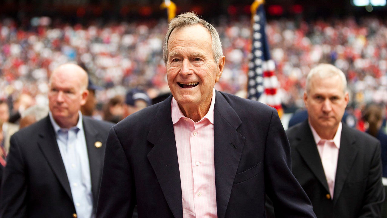 John f kennedy and george w bush at a football game.