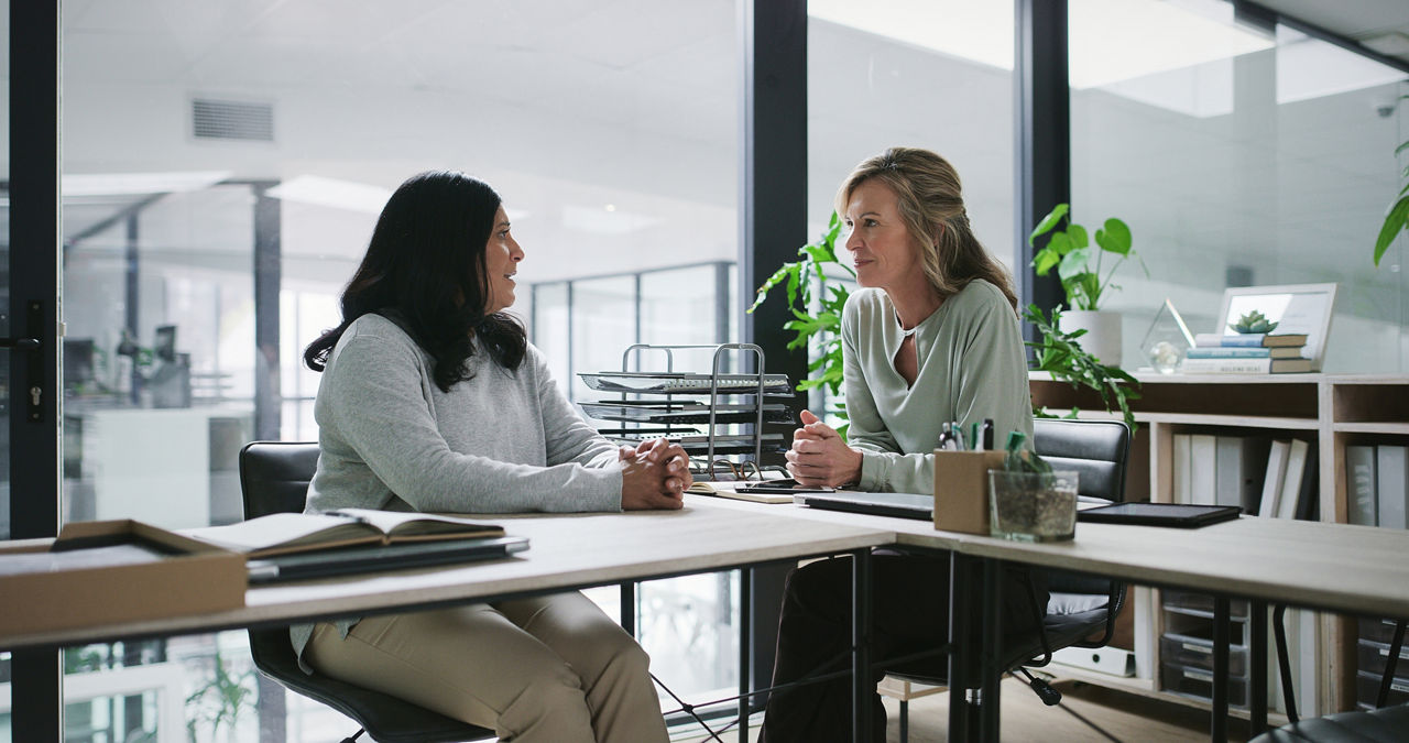 a manager and employee sitting down in discussion