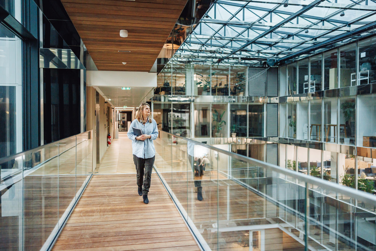 woman walking down the hallway of a large office