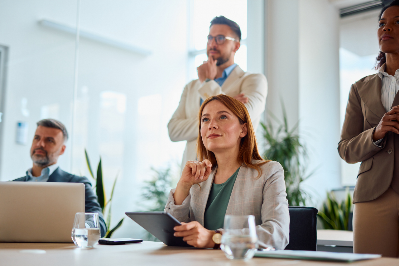 Group of businesspeople engaged in listening to a presentation in a conference room, concentrating on the discussion while generating innovative ideas and strategies for success