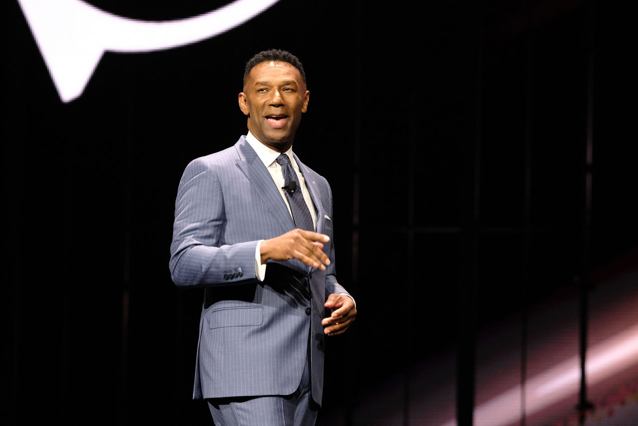 Johnny C. Taylor standing on stage looking toward an audience