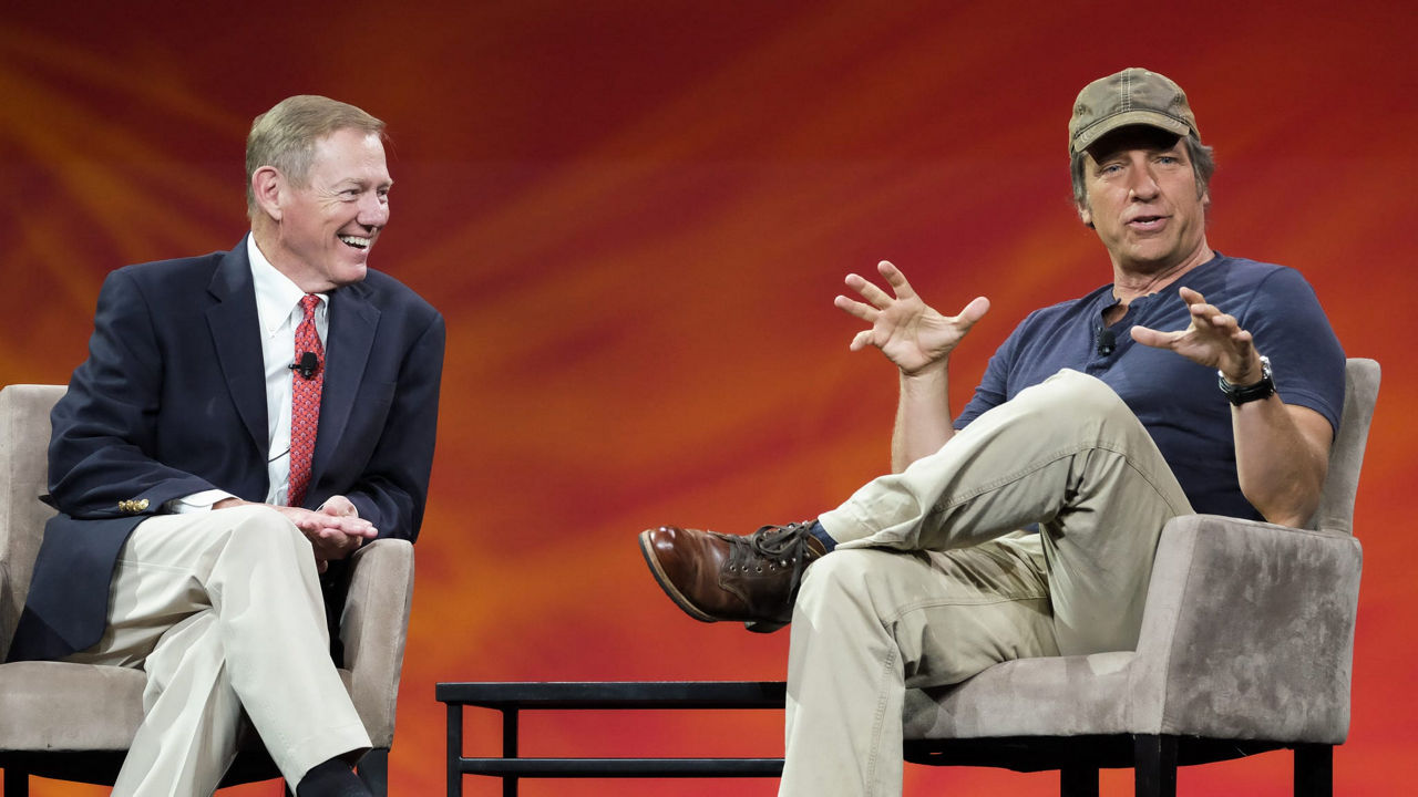 Two men sitting on chairs talking.