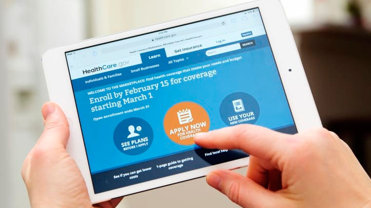 A person holding an ipad with the hhs website on it.