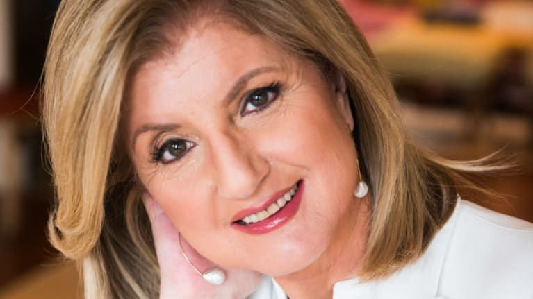 A woman in a white blazer is posing for a photo.