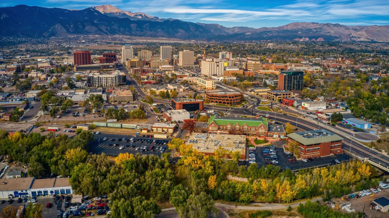 An aerial view of the city of colorado with mountains in the background.