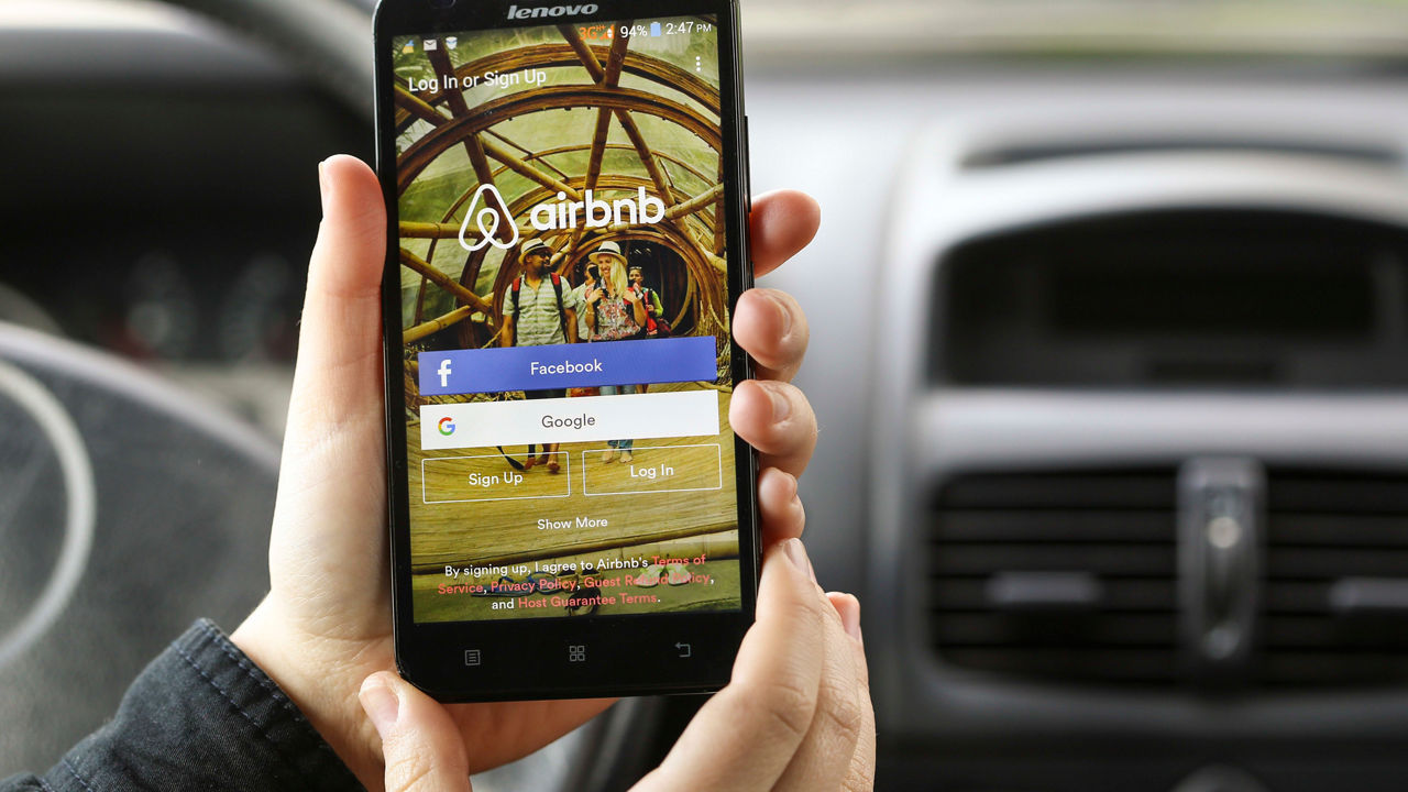 A person holding a cell phone with an adobe app on it.