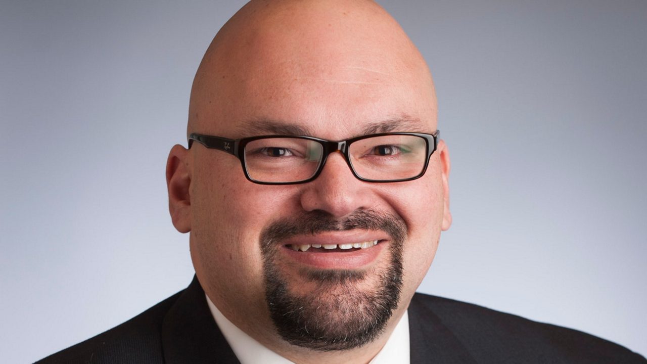 A man in a suit and tie smiling.