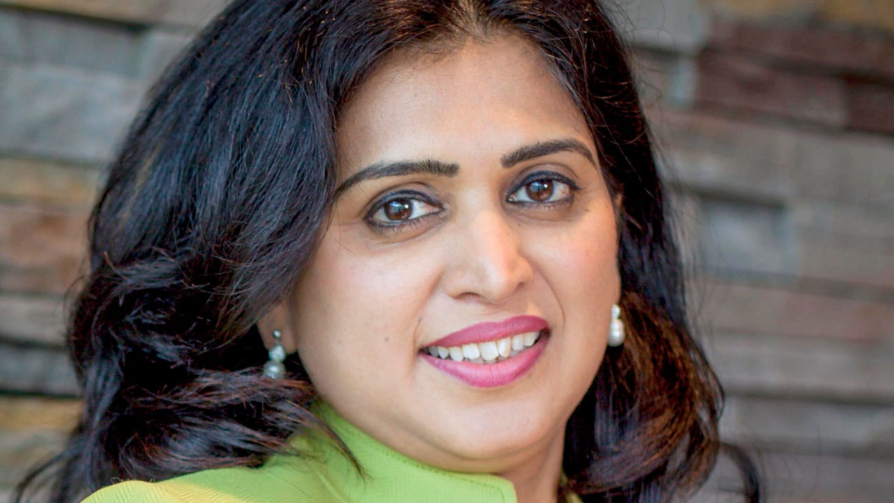 A woman in a green jacket posing for a photo.