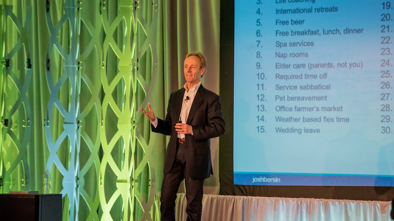 A man giving a presentation in front of a screen.