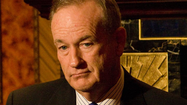 A man in a suit and tie holding a microphone.