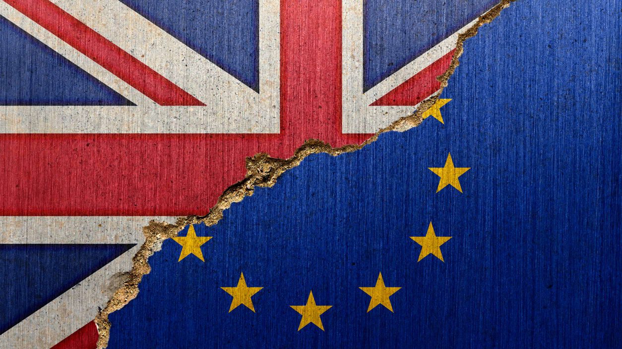 The british flag and the eu flag are torn apart.