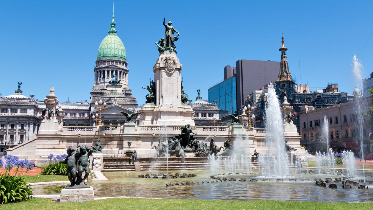 A fountain with statues in front of a building.