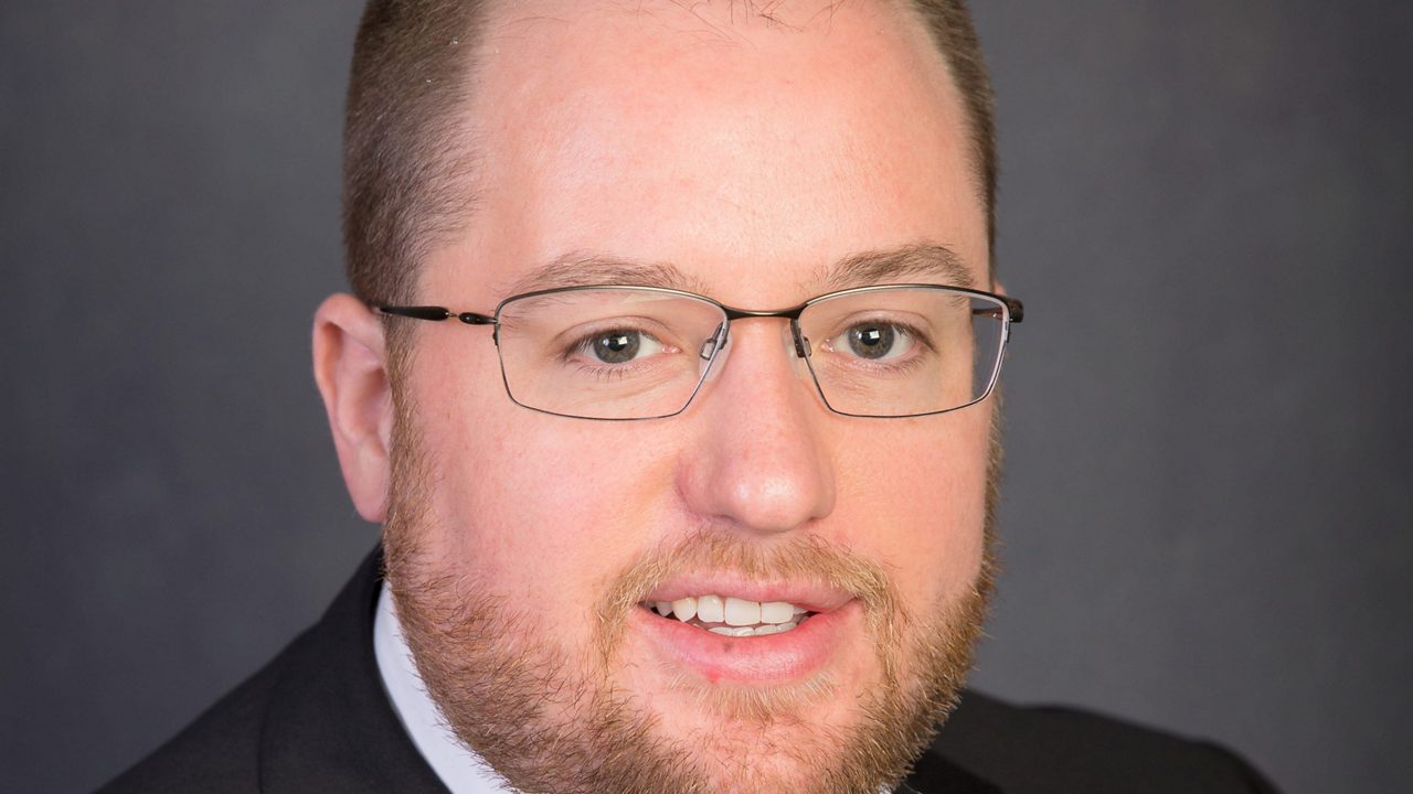 A man in a suit and tie is posing for a photo.