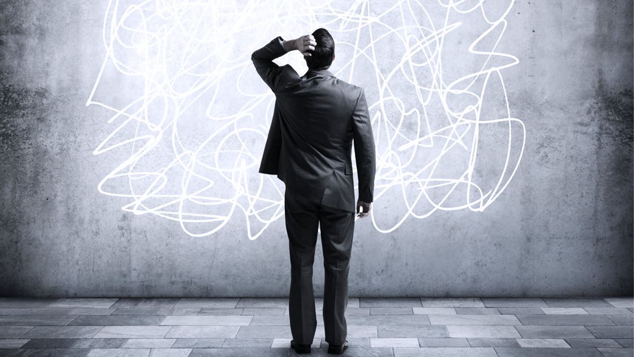 A businessman in a suit standing in front of a chalk drawing.