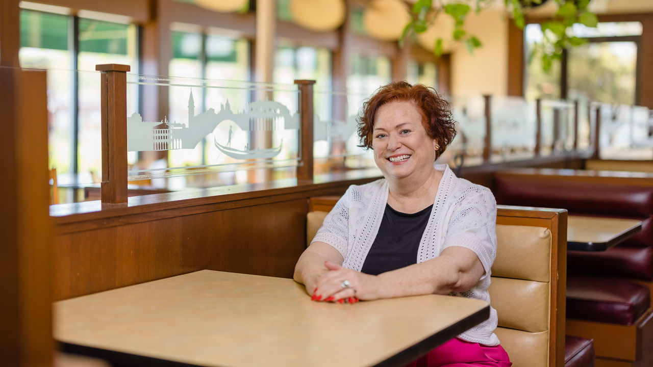 A woman sitting at a table in a restaurant.