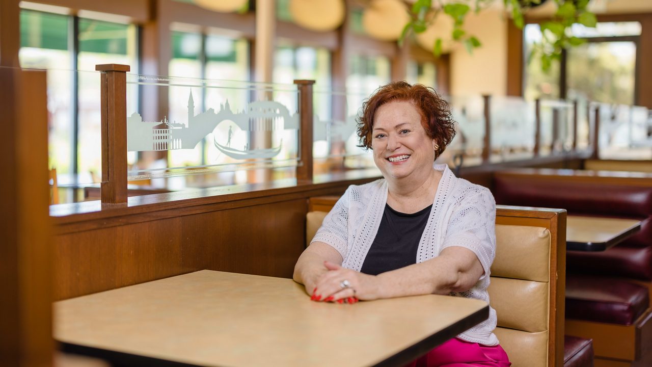 A woman sitting at a table in a restaurant.