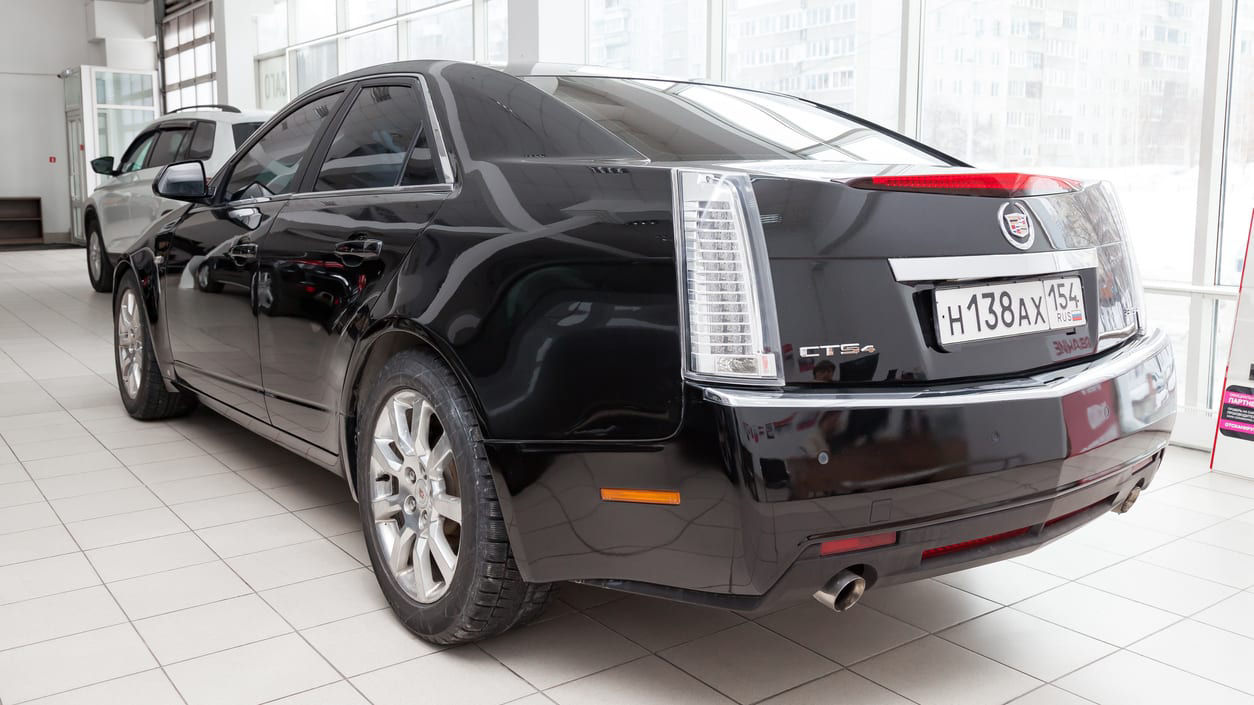 A black cadillac cts parked in a showroom.