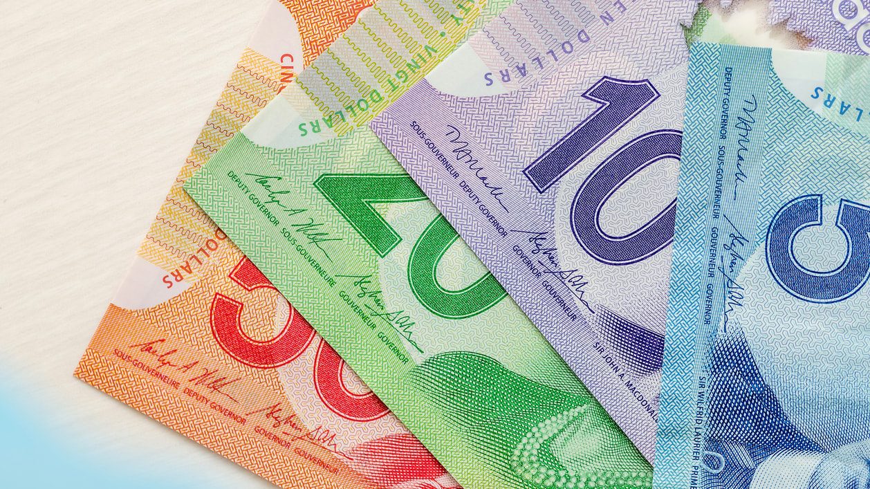 A group of canadian currency notes on a table.