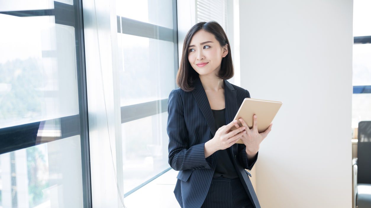 A young asian business woman using a tablet computer in an office.