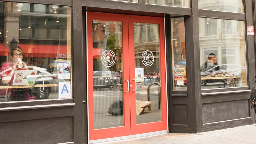 A chipotle restaurant on the corner of a street.