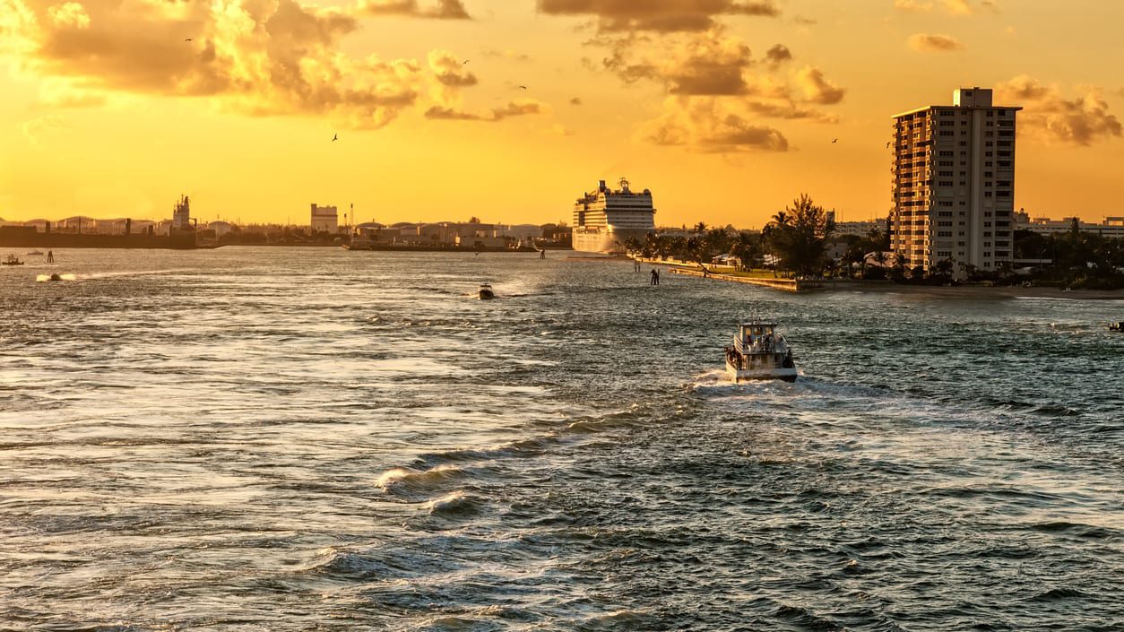 A cruise ship traveling down the river at sunset.