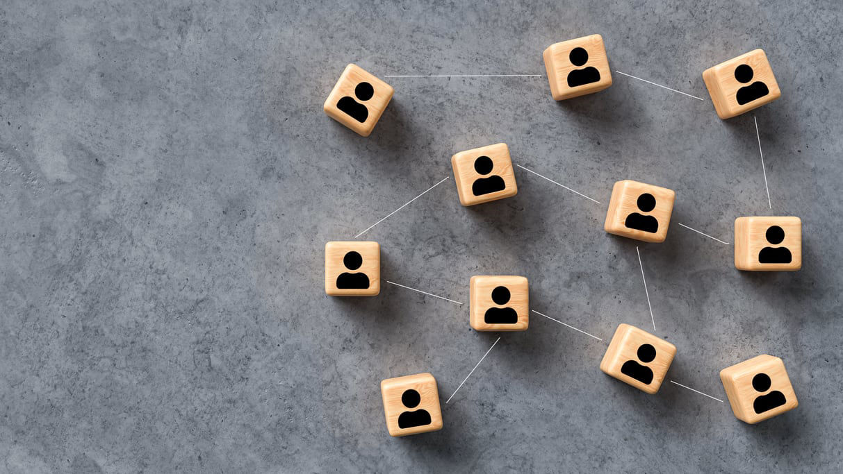 A group of wooden people on a concrete background.