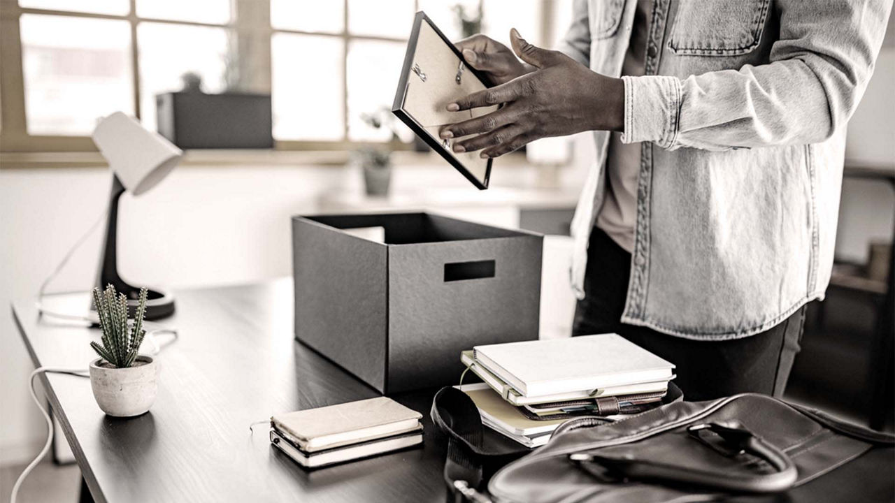A man is holding a tablet in front of a box.