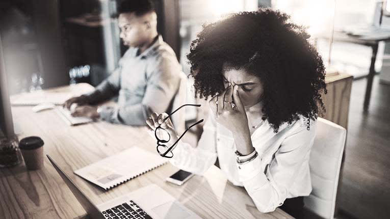 Two people sitting at a desk in an office.