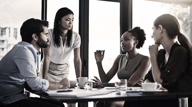 A group of business people sitting around a table.