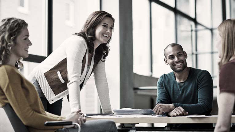 A group of people sitting around a table in an office.