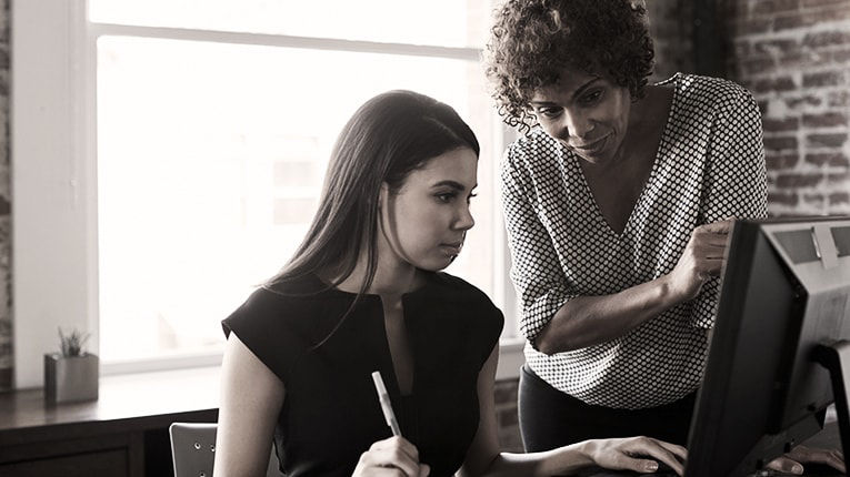 Two women looking at a computer screen.