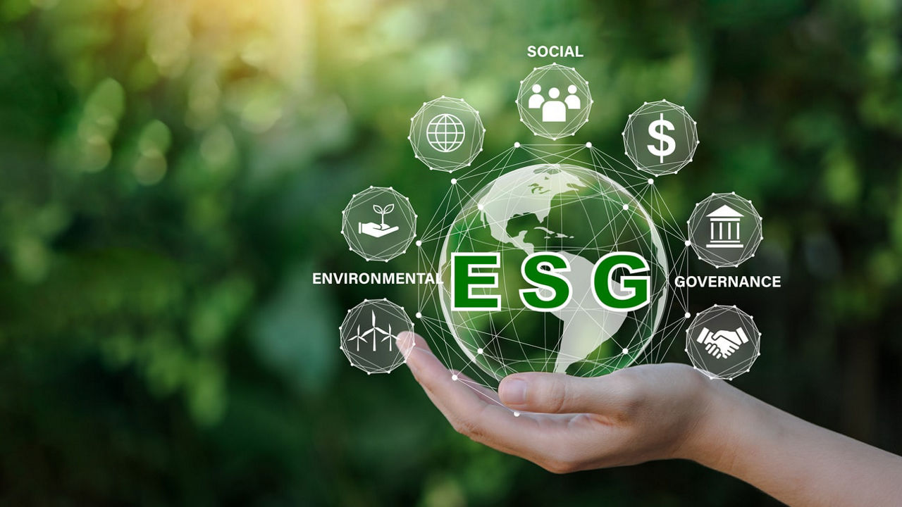 A hand holding a globe with the word esg on it.