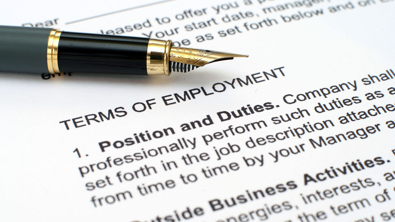 A pen sits on top of a document that says terms of employment.