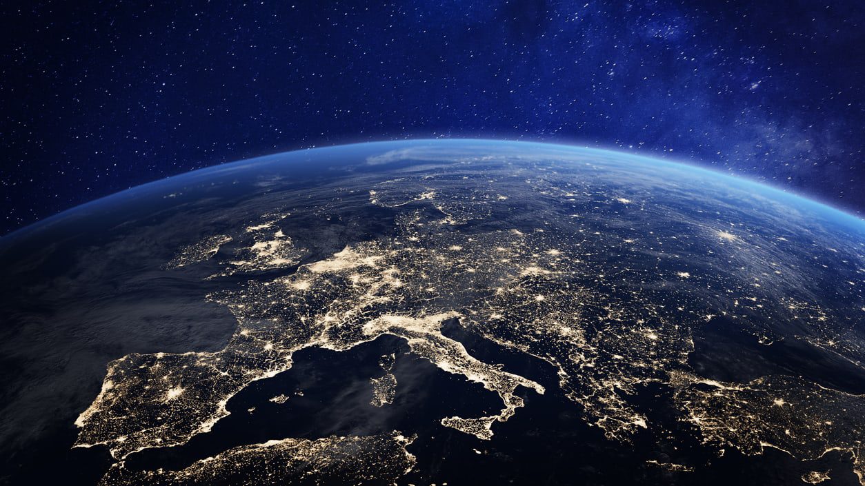 The earth at night with lights shining on it.