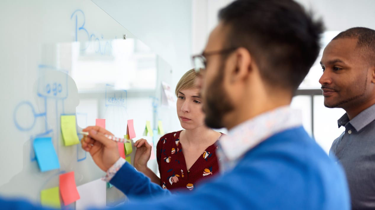 A group of people working together on a whiteboard.