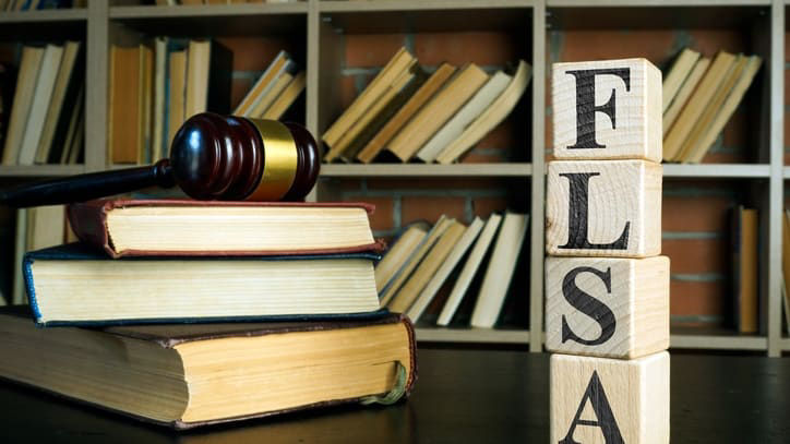 A wooden block with the word flsa on top of it.